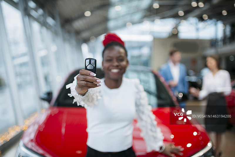 非洲裔女人在展厅展示她的新车钥匙图片素材
