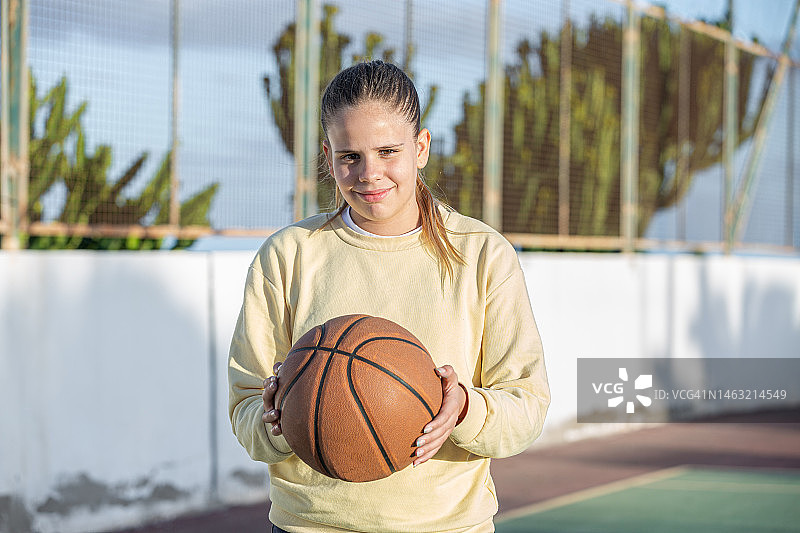 在运动场上拿着篮球的少女图片素材