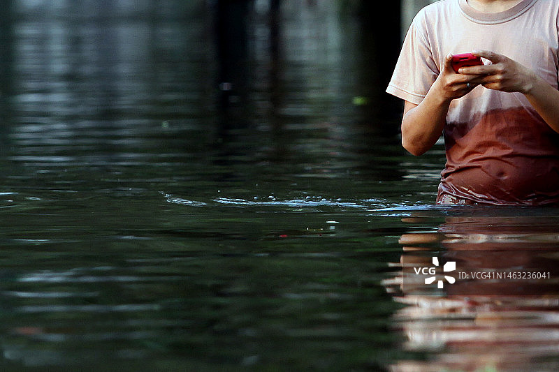 在洪水中行走并发送消息图片素材