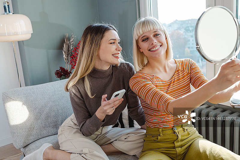手持镜子的美丽年轻女子图片素材