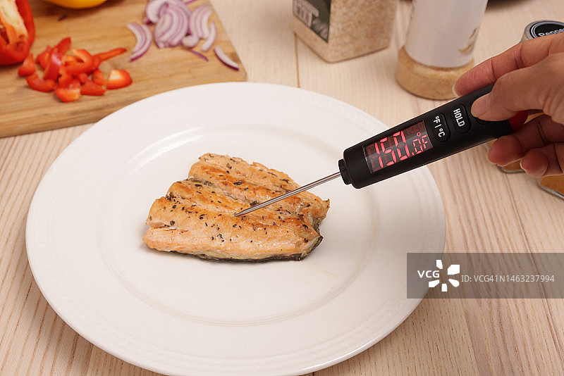 女人检查盘中三文鱼的温度图片素材