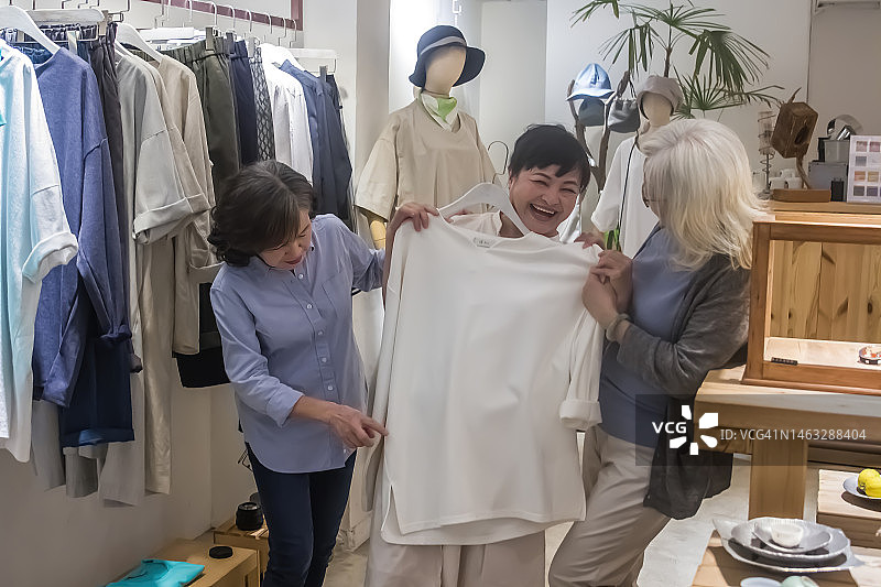 三个中年妇女挑选新衣服图片素材