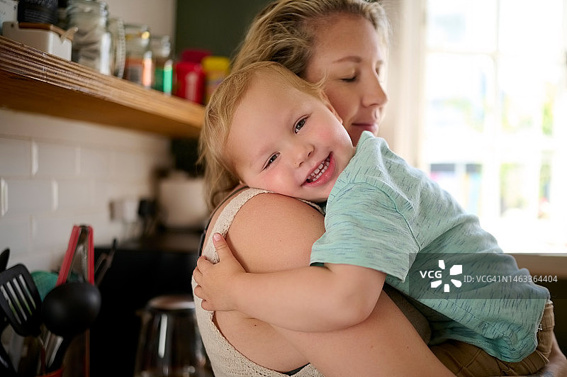 爱，母爱，母亲和婴儿在厨房里拥抱图片素材