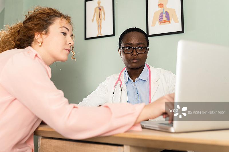 非裔美国女医生在诊所为女病人看病图片素材
