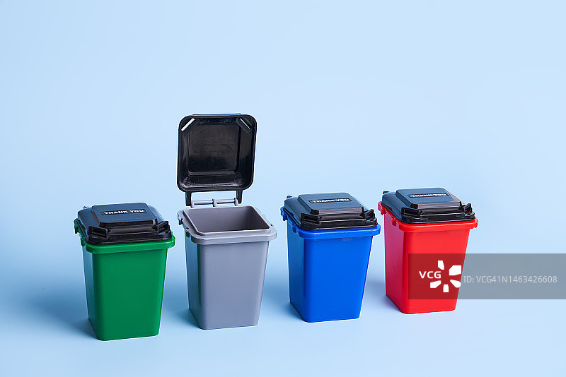 蓝色背景上不同颜色的可回收垃圾箱图片素材