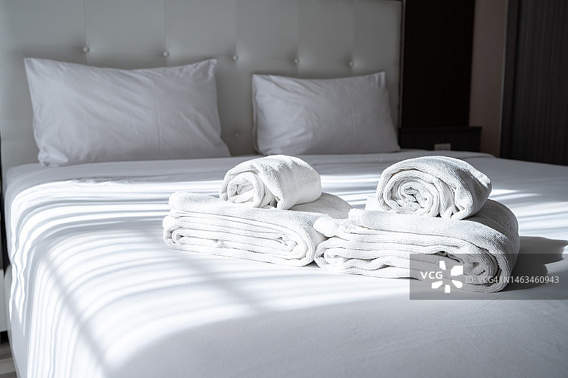 酒店卧室里放着毛巾的舒适床铺图片素材
