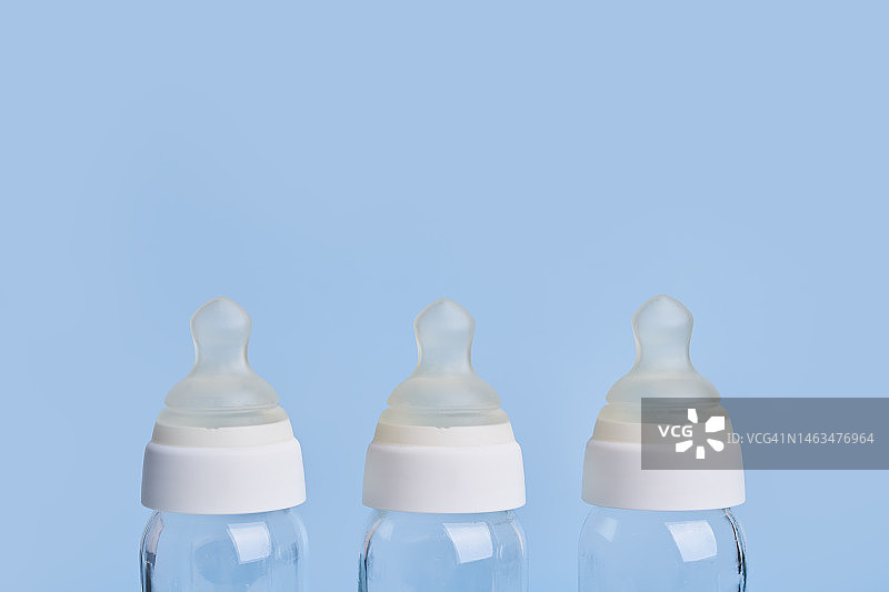 蓝色背景上的三个玻璃奶瓶图片素材