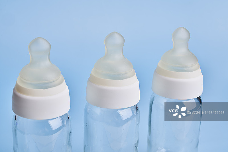 蓝色背景上的三个玻璃奶瓶图片素材