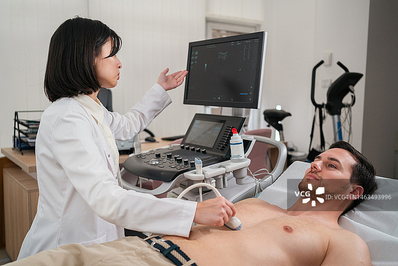 在医疗诊所，女医生为男病人做超声检查图片素材