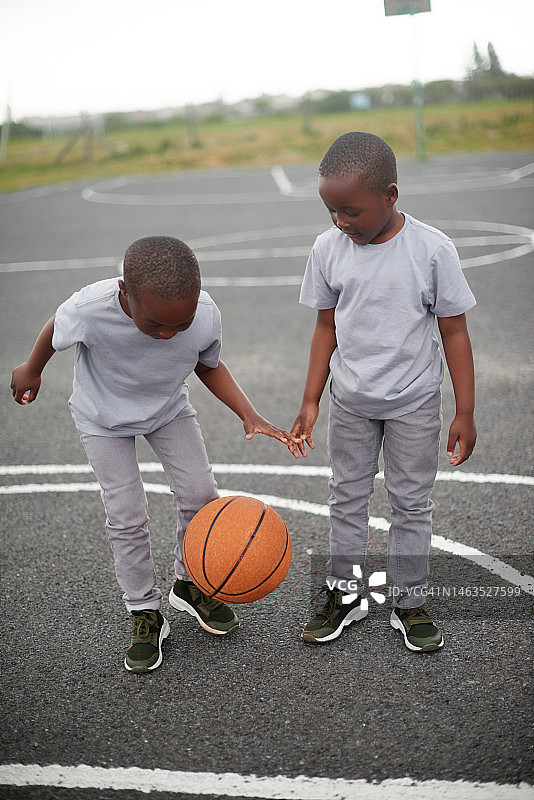 黑人男孩和哥哥在户外球场一起打篮球图片素材