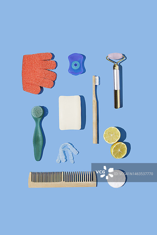 粉色石英刮痧工具、柠檬、发刷等蓝色背景图片素材