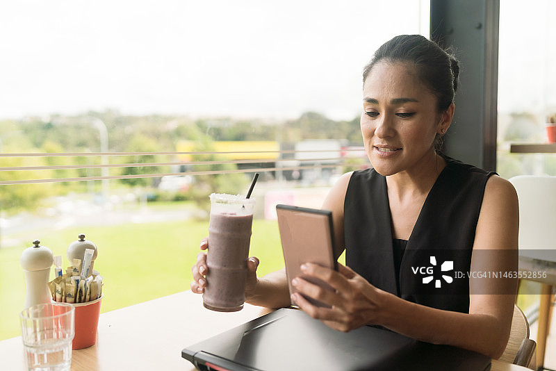 在咖啡馆查看手机邮件的女人图片素材