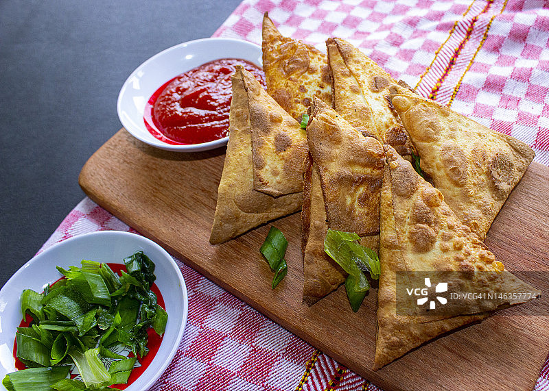 搭配番茄酱和韭菜的油炸三角饺子图片素材