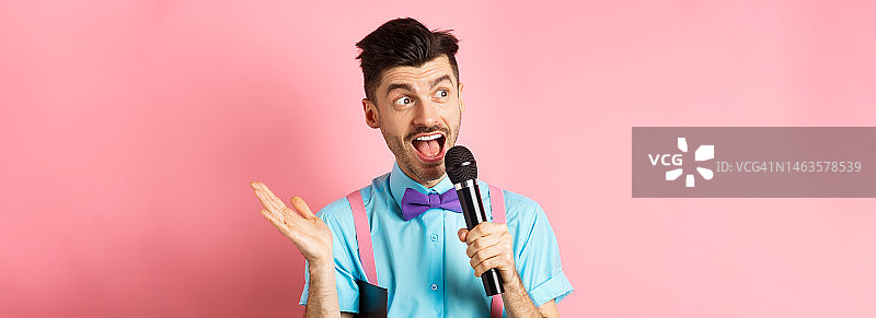 男主持人用麦克风发表演讲图片素材