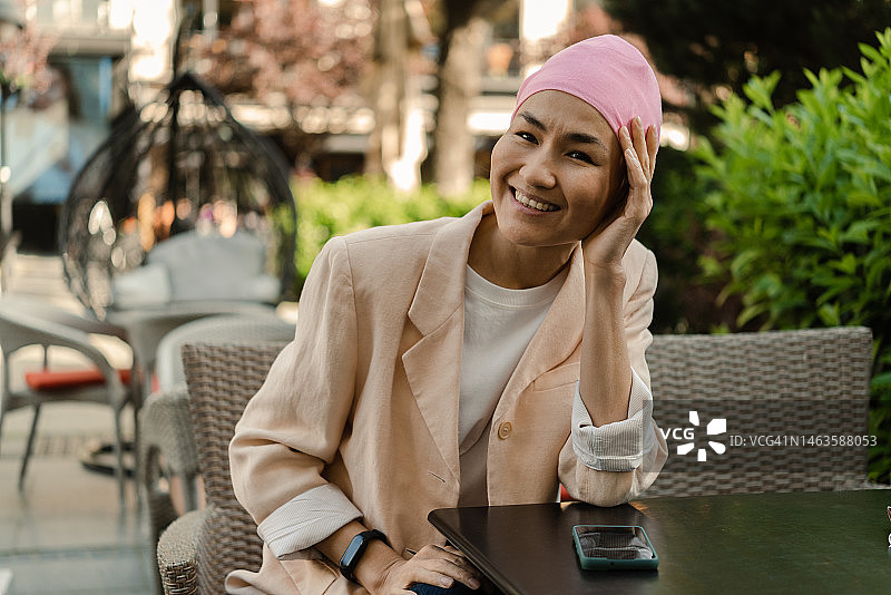 在咖啡馆放松的患癌亚洲女性肖像图片素材