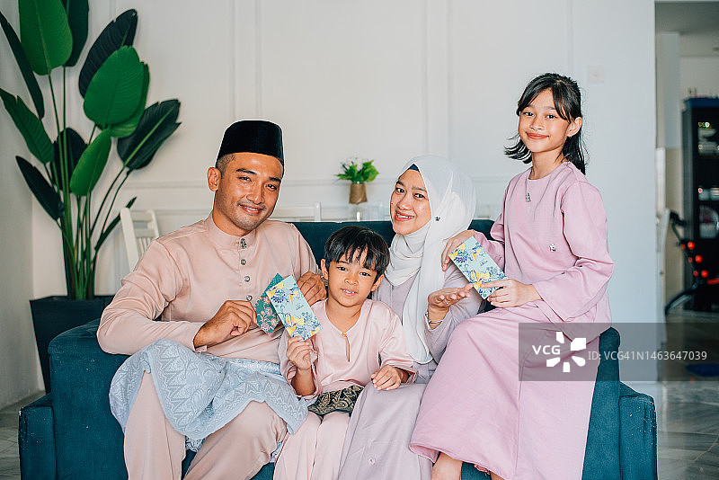 马来穆斯林家庭在客厅庆祝开斋节图片素材