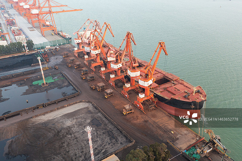 傍晚时分，工业船在海边卸货图片素材