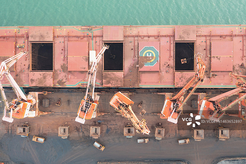 傍晚时分，工业船在海边卸货图片素材