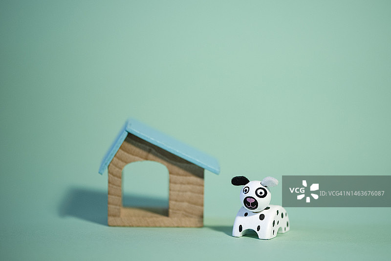 绿色背景上的木制狗屋和木制玩具图片素材