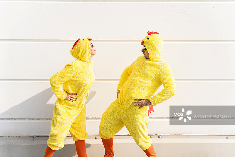 朋友们穿着小鸡服装在墙前玩耍图片素材