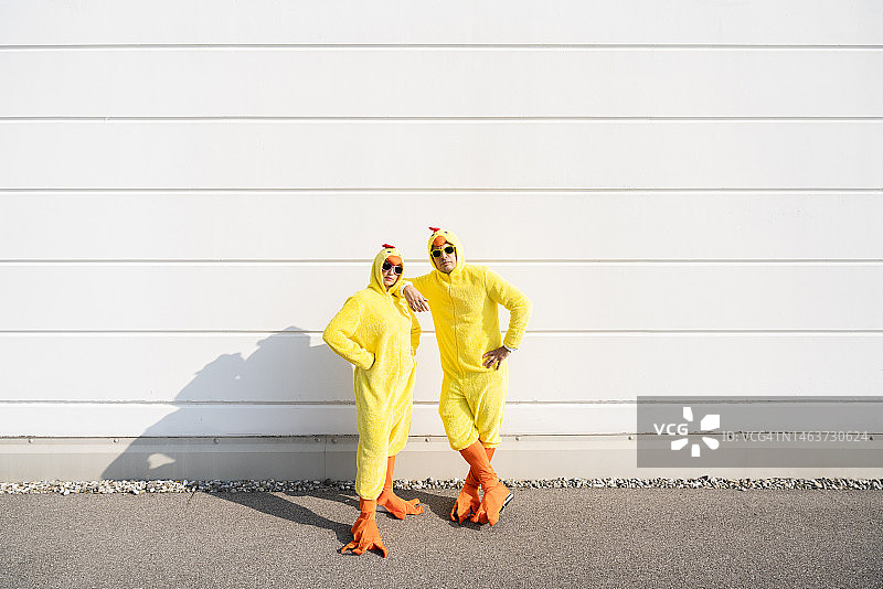 朋友们穿着小鸡服装站在白墙前图片素材