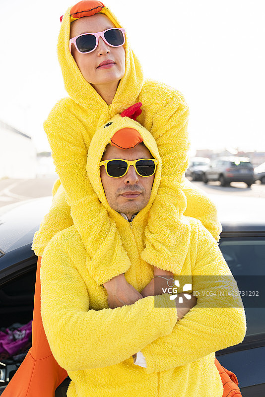 戴着太阳镜和黄色小鸡服装的朋友们在车前图片素材