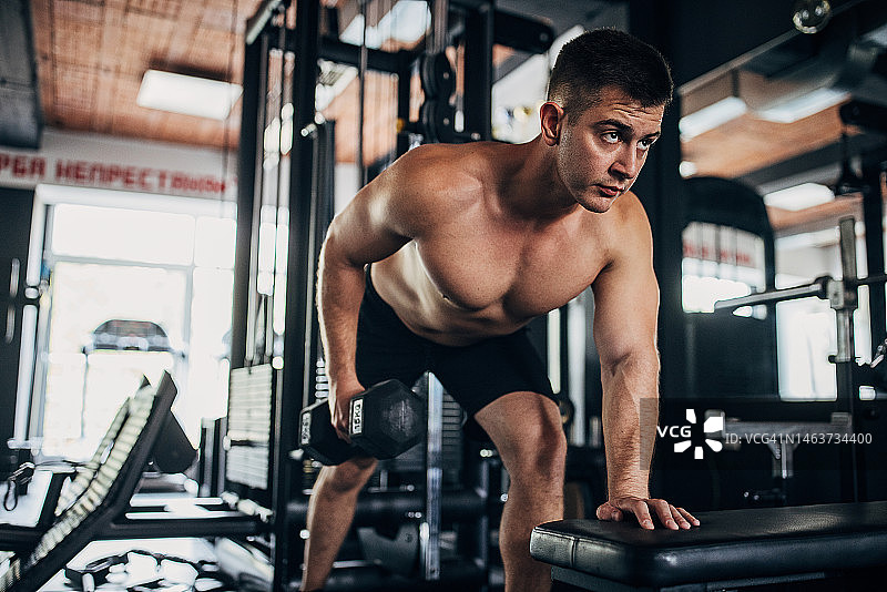 赤膊男人用哑铃锻炼图片素材