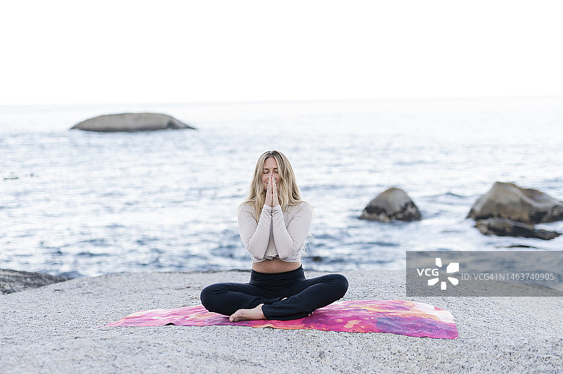 女人在海边盘腿祈祷图片素材