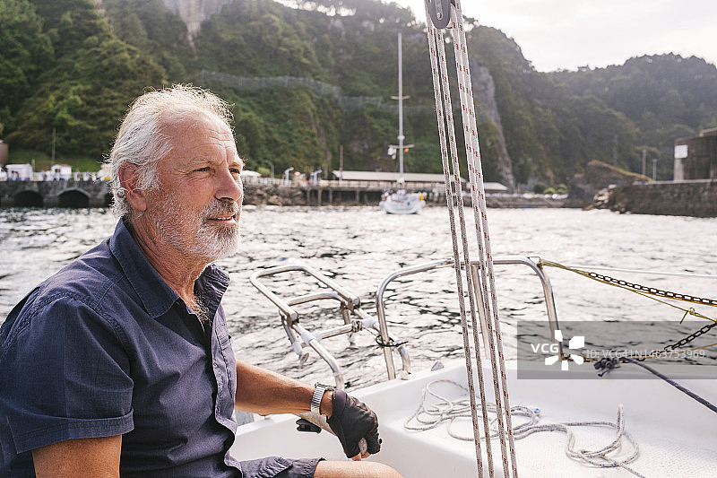 若有所思的年长男子在航行船只图片素材