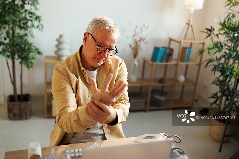一个年长的老年男子的肖像有疼痛在他的手图片素材