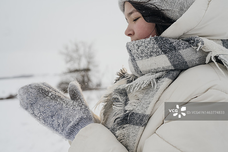 站在冬季景观中戴着手套的少女图片素材