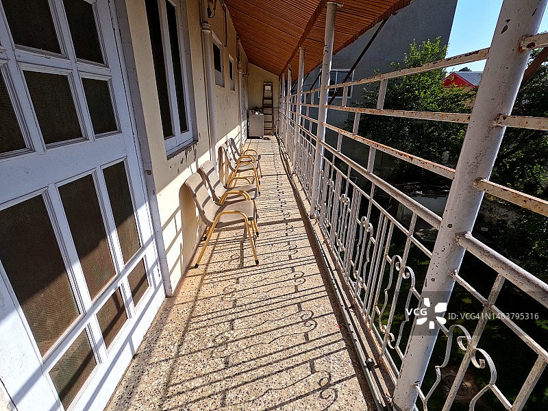 白色金属雕花阳台栏杆、窗户和椅子图片素材