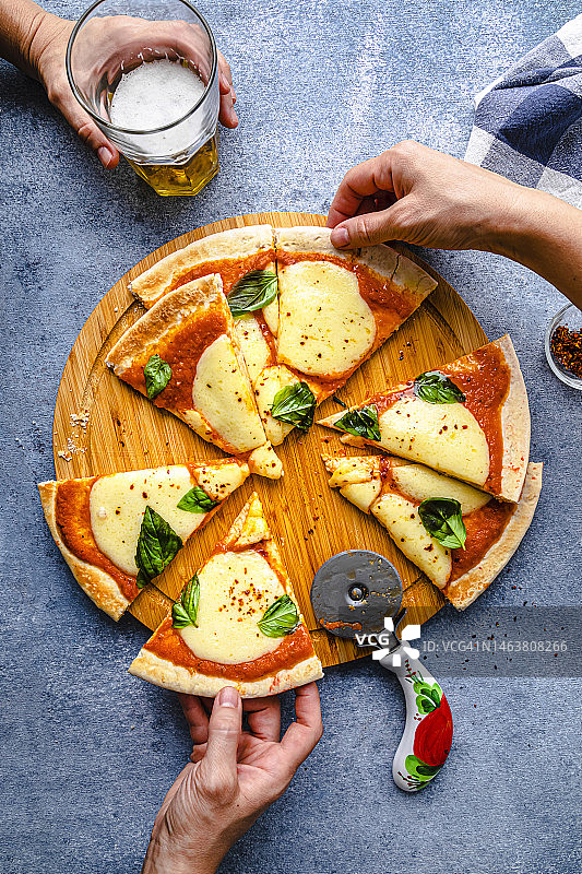 派对上手持披萨和啤酒杯的手图片素材