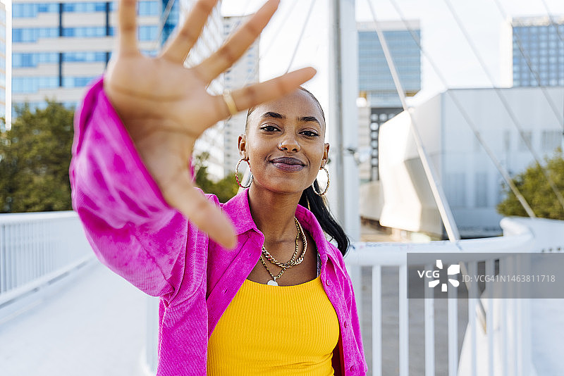 笑容满面的年轻舞者在人行天桥上手势表达图片素材