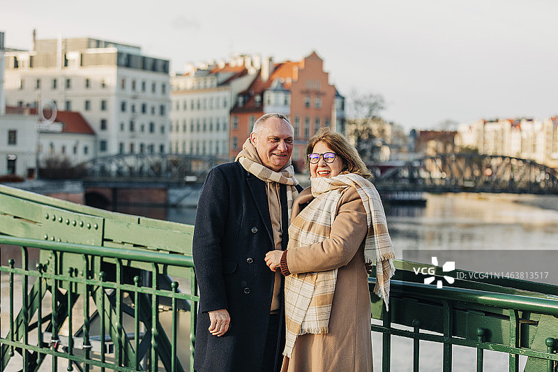 快乐的老年夫妇站在栏杆旁图片素材