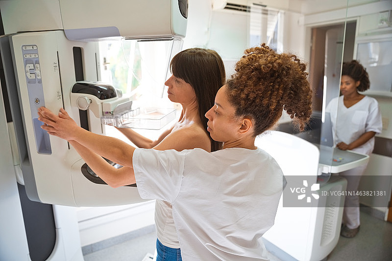 女医生和病人在检查室进行乳房X光检查图片素材