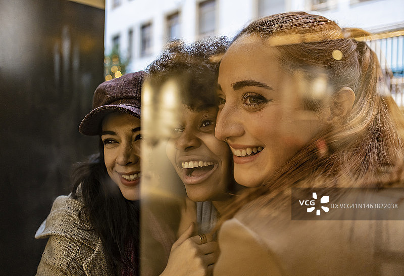 透过玻璃看到的欢快的朋友们图片素材