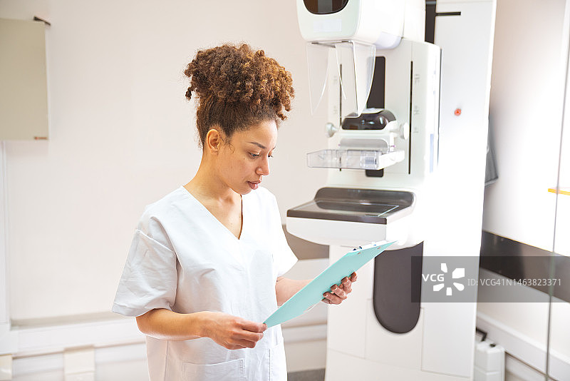 年轻女医护专家在检查室阅读医疗报告图片素材