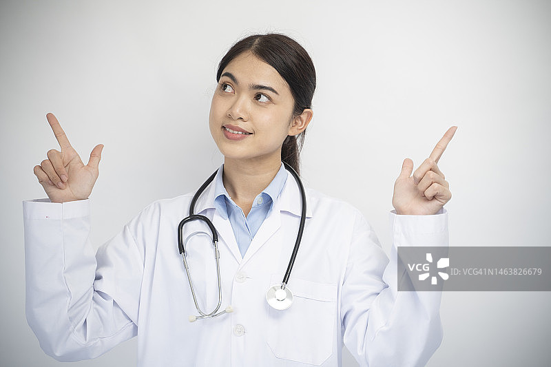 在白色背景上指向上方的女医生图片素材
