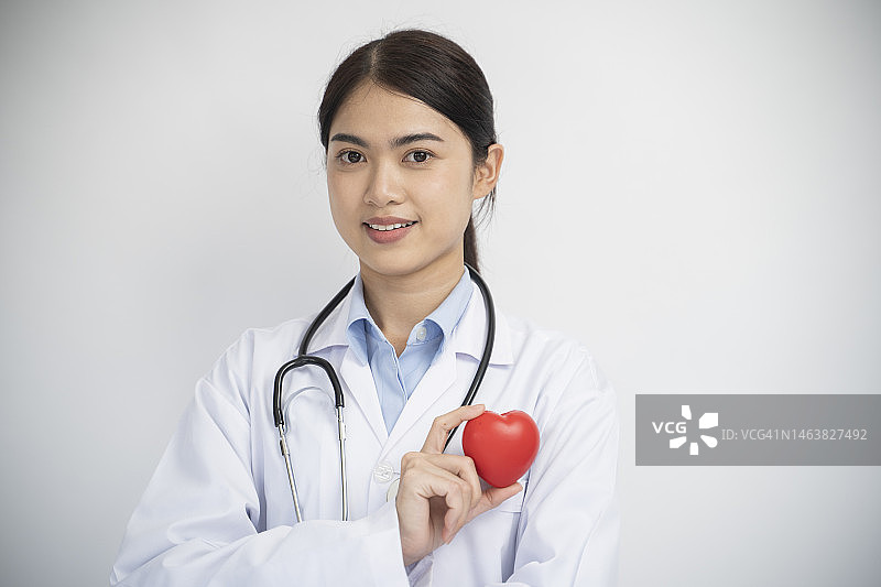 面带微笑的亚洲女医生悉心照料病人，比心图片素材