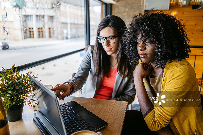 两个女人在咖啡馆用笔记本电脑工作图片素材