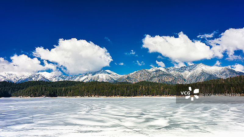 德国格赖瑙艾布湖的冰冻湖面、雪山和多云天空图片素材