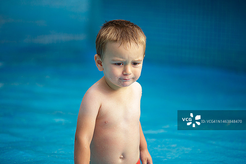 西班牙塞哥维亚，一个悲伤的小男孩从游泳池里出来图片素材
