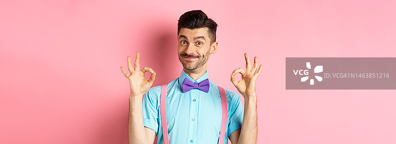 留着胡子、系着领结，做出OK手势的英俊男人肖像图片素材