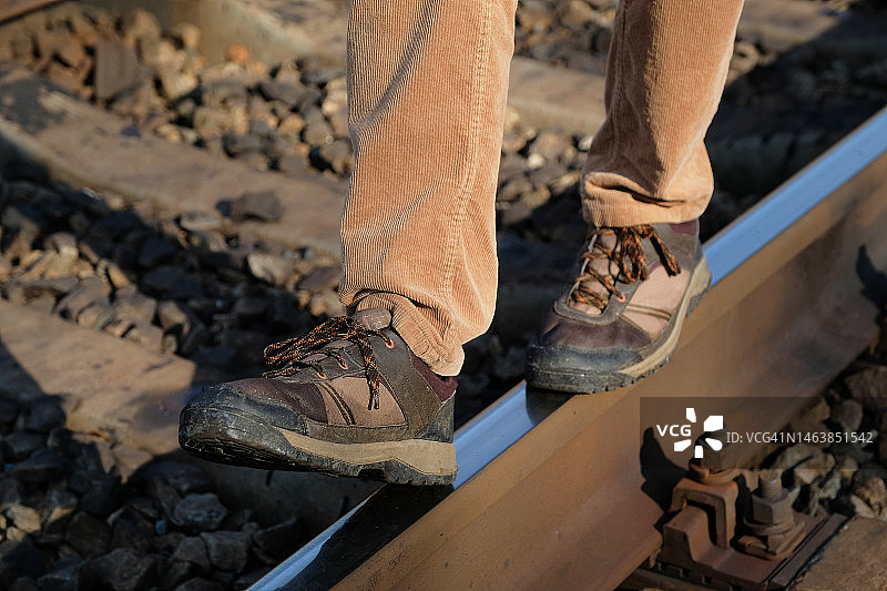 一个孤独的男人在工业区沿着铁路轨道行走图片素材