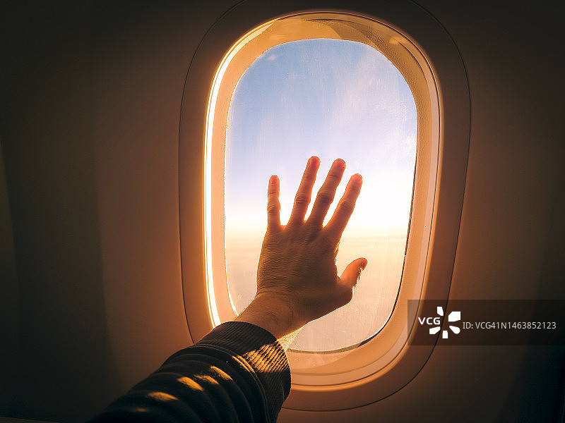 日落时分触摸飞机舷窗图片素材