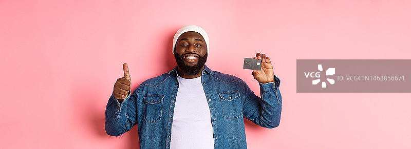 购物概念：推荐银行的英俊非裔美国男子图片素材