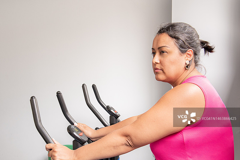 在健身自行车上训练的女人图片素材