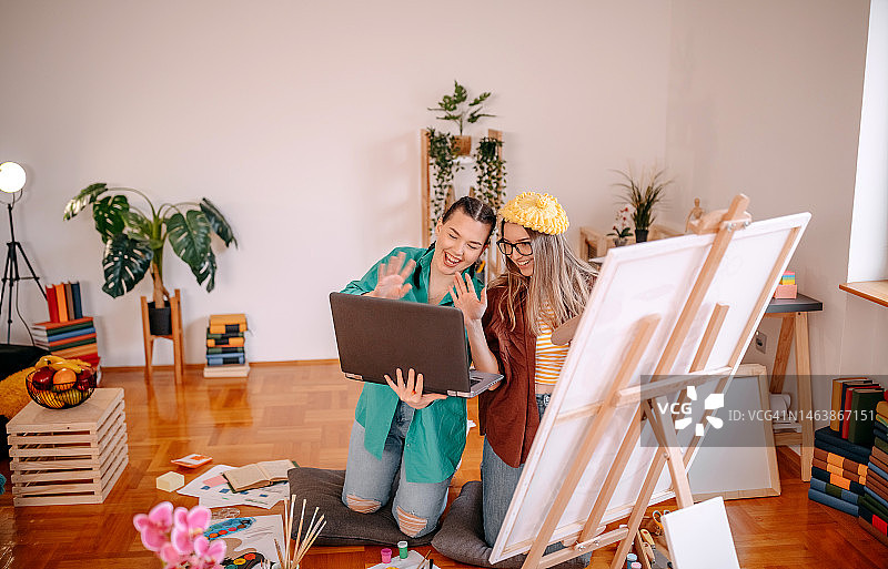 年轻女艺术家在家与室友一起创作绘画图片素材
