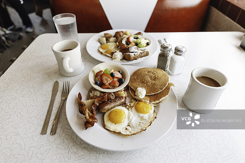 美式传统餐点：含薄烤饼、鸡蛋、培根和水果的早餐图片素材